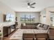 Spacious living room featuring an oversized couch, gas fireplace, and a view of the pond at 11641 Crowned Sparrow Ln, Tampa, FL 33626
