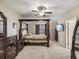 Luxurious main bedroom with a four-poster bed, dressers, and ample space for a serene retreat at 11641 Crowned Sparrow Ln, Tampa, FL 33626