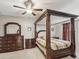 Elegant main bedroom featuring a four-poster bed, a ceiling fan, and matching dressers, exuding comfort at 11641 Crowned Sparrow Ln, Tampa, FL 33626