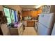 Efficient kitchen features wooden cabinets, white appliances, and a window overlooking the outdoors at 11711 Raintree Village Blvd # C, Temple Terrace, FL 33617