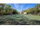 Community tennis court surrounded by lush greenery with benches, perfect for residents to enjoy sports at 11711 Raintree Village Blvd # C, Temple Terrace, FL 33617