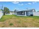 Large backyard with a screened porch, air conditioning unit, and white fencing at 11973 80Th Ave, Seminole, FL 33772