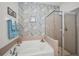 The main bath features soaking tub, glass-enclosed shower, and decorative herringbone accent wall at 13207 San Blas Loop, Largo, FL 33774