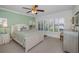 Bright bedroom with white furniture, carpet, ceiling fan, plantation shutters, and a serene green accent wall at 13207 San Blas Loop, Largo, FL 33774