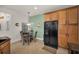 Sunlit breakfast nook features wooden cabinets, a black refrigerator, and a four-chair glass table at 13207 San Blas Loop, Largo, FL 33774