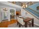 Bright dining area with chandelier, hardwood floors, and staircase access to the second floor at 13207 San Blas Loop, Largo, FL 33774