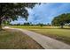 Paved path winds through the picturesque Largo Golf Course, surrounded by lush greenery and trees at 13207 San Blas Loop, Largo, FL 33774
