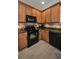 Well-lit kitchen features wooden cabinets, a black microwave and oven, and tile backsplash at 13207 San Blas Loop, Largo, FL 33774