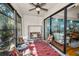 Enclosed lanai with ceiling fan, comfortable furniture, and sliding glass doors to the home's interior at 13207 San Blas Loop, Largo, FL 33774