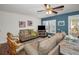Inviting living room with comfortable seating, ceiling fan, plantation shutters, and blue accent wall at 13207 San Blas Loop, Largo, FL 33774