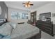 The spacious main bedroom has a wooden dresser, ceiling fan, and glass doors to a patio and a window for natural light at 13207 San Blas Loop, Largo, FL 33774