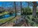 Tranquil pond featuring a fountain, trees, and foliage next to a bench, creating a peaceful retreat at 13207 San Blas Loop, Largo, FL 33774