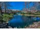 Scenic view of a pond featuring a fountain, lush landscaping, and surrounding community residences at 13207 San Blas Loop, Largo, FL 33774