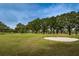 Golf course view featuring a sand trap, lush green, trees, and blue skies at 13207 San Blas Loop, Largo, FL 33774