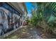 View of the side yard with an outdoor grill, vegetation, and access to the home's screened-in lanai at 13207 San Blas Loop, Largo, FL 33774