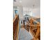 Carpeted staircase with wood railing leads down to the living room in this home with high ceilings at 13207 San Blas Loop, Largo, FL 33774