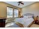 Cozy bedroom with a wrought iron bed frame, two windows, and a guitar standing near a night stand at 13812 Fairway Bunker Dr, Tampa, FL 33626