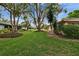 Expansive backyard featuring a lush lawn and mature trees, creating a serene outdoor space at 1426 Ingram Dr # 1426, Sun City Center, FL 33573