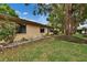 Well-kept backyard with a green lawn, mature trees offering shade, and decorative stones at 1426 Ingram Dr # 1426, Sun City Center, FL 33573