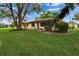 Home exterior with well-maintained lawn and mature trees, offering a tranquil setting at 1426 Ingram Dr # 1426, Sun City Center, FL 33573
