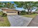 Charming home featuring a two-car garage and a long driveway, surrounded by lush landscaping at 1426 Ingram Dr # 1426, Sun City Center, FL 33573
