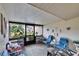 Enclosed front porch featuring comfortable seating and views of the surrounding tropical landscaping at 1426 Ingram Dr # 1426, Sun City Center, FL 33573