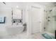 Bright bathroom featuring a modern soaking tub, glass enclosed shower, and sleek white marble floors at 15 Avalon St # 303, Clearwater Beach, FL 33767