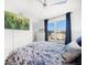 Comfortable bedroom with blue floral bedding, a ceiling fan, and large windows for natural light at 15 Avalon St # 303, Clearwater Beach, FL 33767