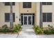 The building entrance with double doors, plants, trees and Pura Vida sign above the doors at 15 Avalon St # 303, Clearwater Beach, FL 33767