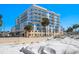 Building exterior view from the beach with balconies and palm trees on a sunny day at 15 Avalon St # 303, Clearwater Beach, FL 33767