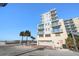 Exterior of building with a parking garage, balconies, palm trees and blue skies at 15 Avalon St # 303, Clearwater Beach, FL 33767