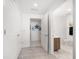 A hallway leading to a bathroom with marble tile, a vanity, and a modern sink at 15 Avalon St # 303, Clearwater Beach, FL 33767