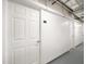 Hallway view of the white doors to the storage units with unit numbers and silver hardware at 15 Avalon St # 303, Clearwater Beach, FL 33767