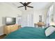 Bedroom with hardwood floors, ceiling fan, natural light, a TV, and a desk at 16011 Bella Woods Dr, Tampa, FL 33647