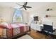 Cozy bedroom with hardwood floors, a ceiling fan, desk and workstation with a window view at 16011 Bella Woods Dr, Tampa, FL 33647