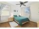 Cozy bedroom with hardwood floors, natural light, and a ceiling fan at 16011 Bella Woods Dr, Tampa, FL 33647