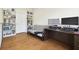 Office with hardwood floors, a futon, and shelving with a desk; great for work and study at 16011 Bella Woods Dr, Tampa, FL 33647