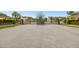 Gated community entrance with black metal gates, brick columns, and landscaping at 16011 Bella Woods Dr, Tampa, FL 33647