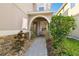 Home's front porch with stone accents, arched entry, bench, and lush landscaping at 16011 Bella Woods Dr, Tampa, FL 33647