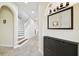 Entryway showcasing a staircase, mirror, light fixture, and neutral tile flooring at 16011 Bella Woods Dr, Tampa, FL 33647