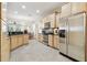Well-lit kitchen with stainless steel appliances, tile floors, and light wood cabinetry and black countertops at 16011 Bella Woods Dr, Tampa, FL 33647