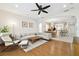 Living room with hardwood floors, a ceiling fan, modern lighting, and an open layout to the kitchen at 16011 Bella Woods Dr, Tampa, FL 33647