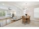 Open-concept living and dining area with hardwood floors, large windows, and a modern chandelier at 16011 Bella Woods Dr, Tampa, FL 33647