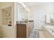Bright main bathroom featuring double sinks, granite counters, a garden tub, and white cabinets at 16011 Bella Woods Dr, Tampa, FL 33647
