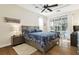 Main bedroom with tray ceiling, ceiling fan, wood floors, and sliding glass doors to the screened lanai at 16011 Bella Woods Dr, Tampa, FL 33647