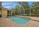 View of a screened-in pool area with brick pavers and a table and chairs at 16011 Bella Woods Dr, Tampa, FL 33647