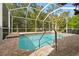 Inviting screened-in pool area surrounded by brick pavers and lush landscaping at 16011 Bella Woods Dr, Tampa, FL 33647