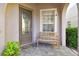 Front porch featuring a decorative glass door, window, bench, and stone pathway at 16011 Bella Woods Dr, Tampa, FL 33647