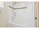 Clean shower featuring a white tub and tiled walls with mosaic accents at 16011 Bella Woods Dr, Tampa, FL 33647