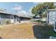 Backyard featuring a screened patio, a fire pit, and a grass area with mature landscaping at 1605 Crown St, Clearwater, FL 33755